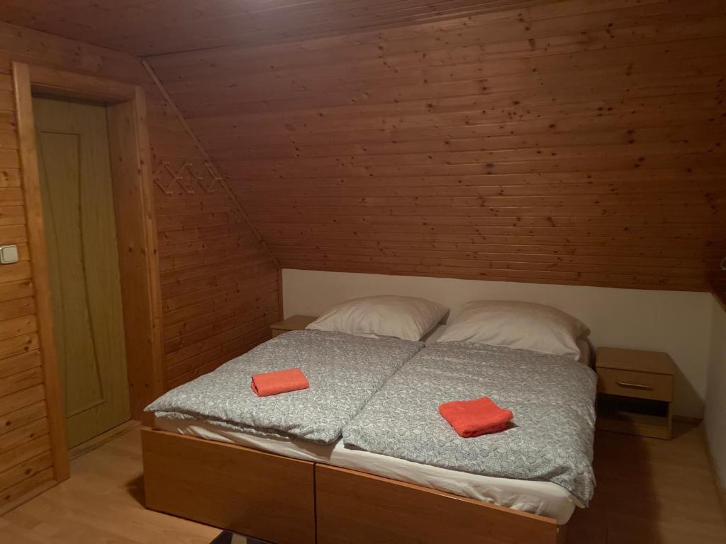 a bedroom with a bed with two red pillows on it at Chalupa ŠŠ in Vlachy