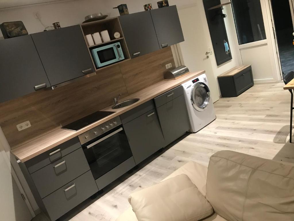 a kitchen with a microwave and a washing machine at Ferienwohnung auf dem Land in Gattendorf
