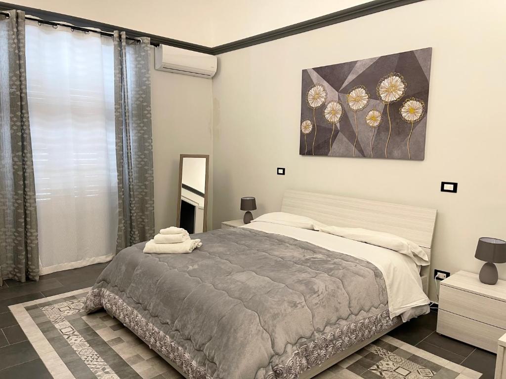 a bedroom with a bed and a painting on the wall at B&B Antichi Cortili in Termini Imerese