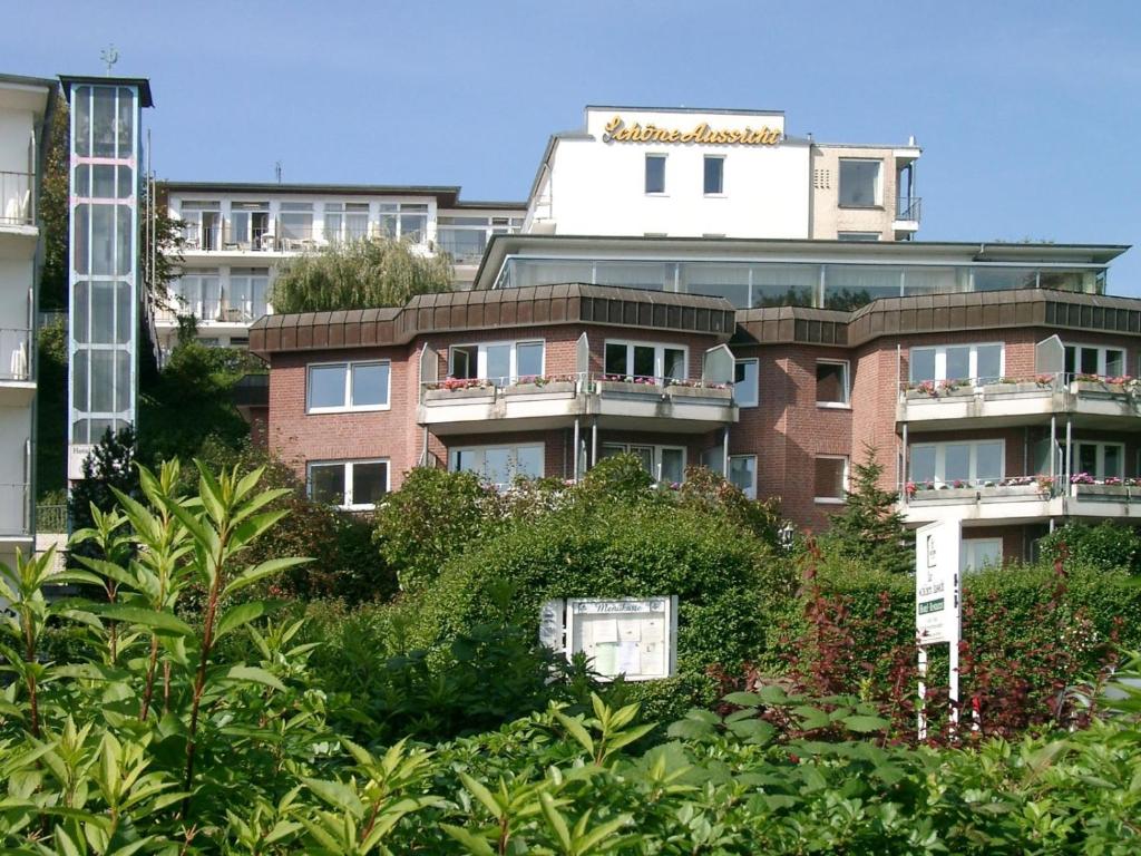 um edifício de tijolos altos com plantas em frente em Hotel Zur schönen Aussicht em Grömitz