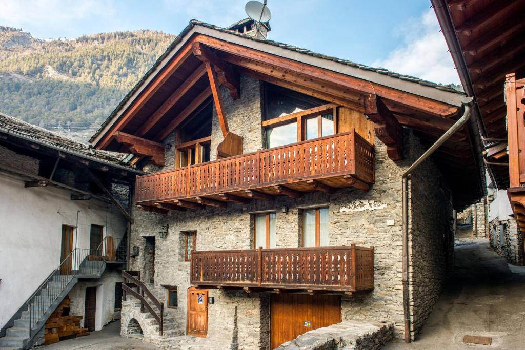 a building with wooden balconies on the side of it at Mont Blanc Apartments in Morgex