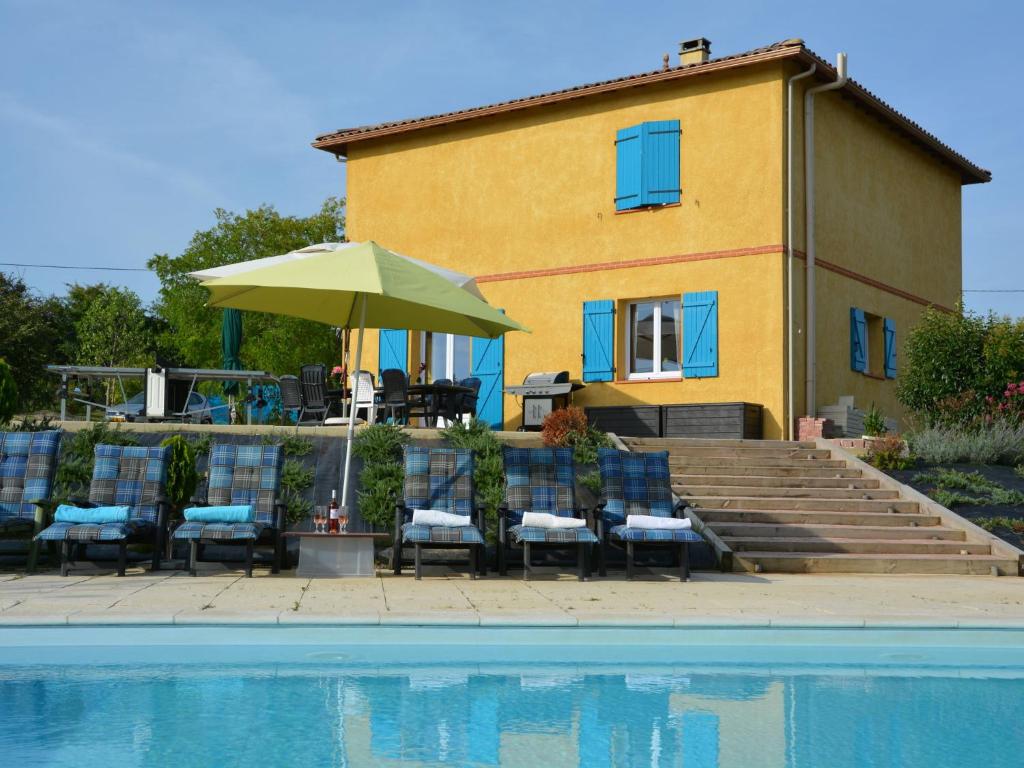dom z krzesłami i parasolem przy basenie w obiekcie Spacious villa in Piquecos with private pool w mieście Piquecos