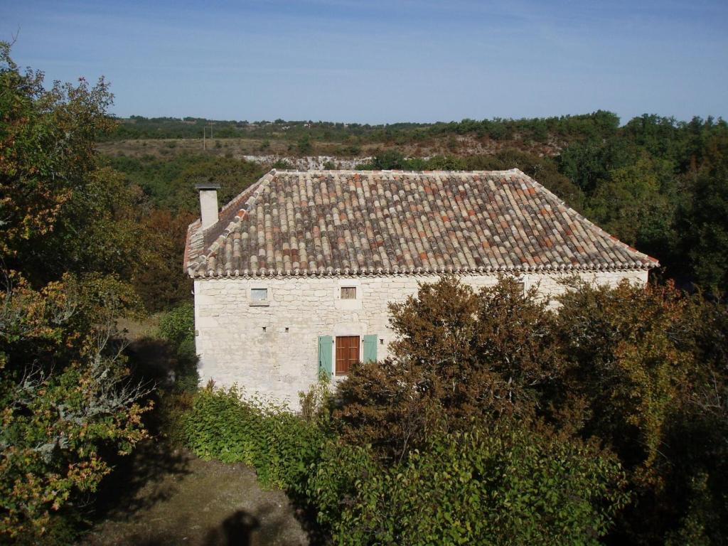 ein altes Steinhaus auf einem Feld mit Bäumen in der Unterkunft Historic holiday home with garden in Fargues