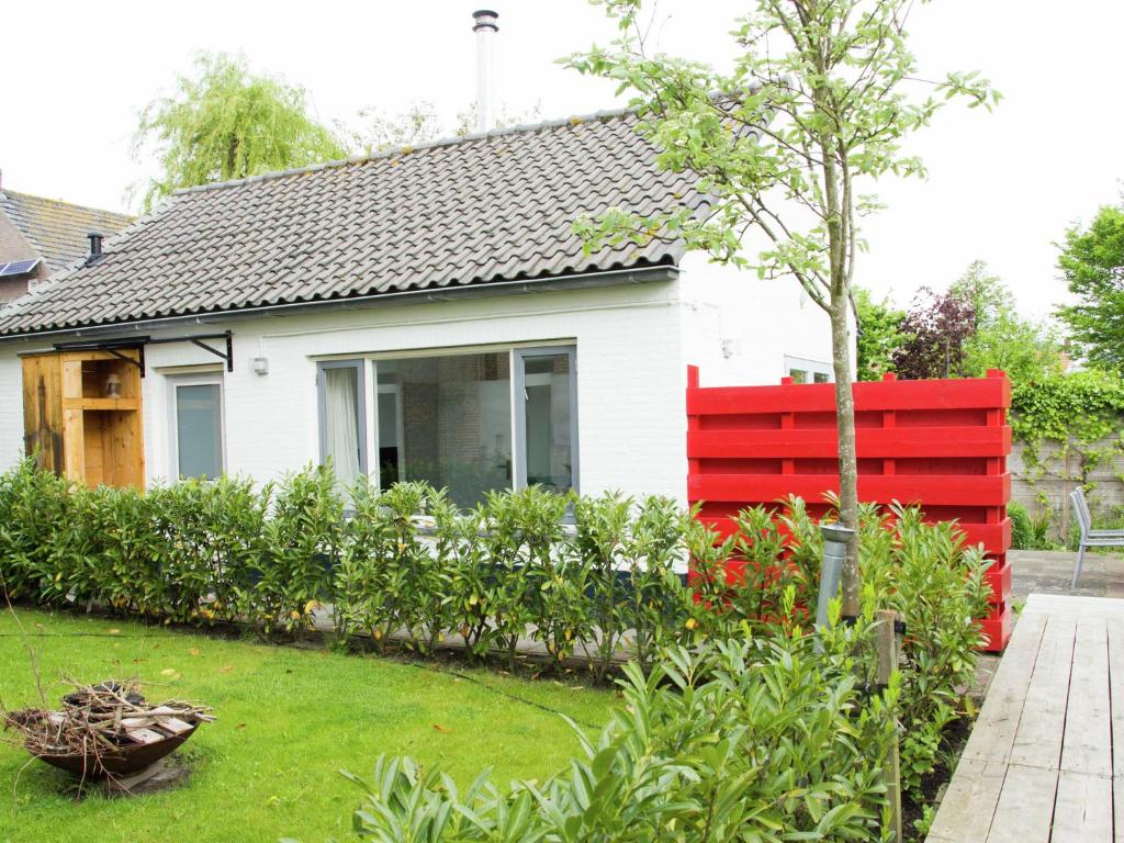 グルーデにあるLovely Cottage near Sea in Groedeの庭の赤いベンチ付きの家