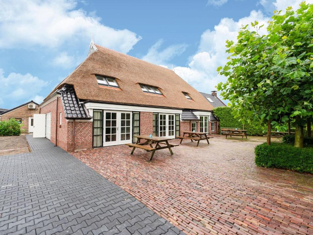 a brick building with two picnic tables in front of it at Gorgeous Farmhouse with Sauna in Noardburgum in Noordbergum