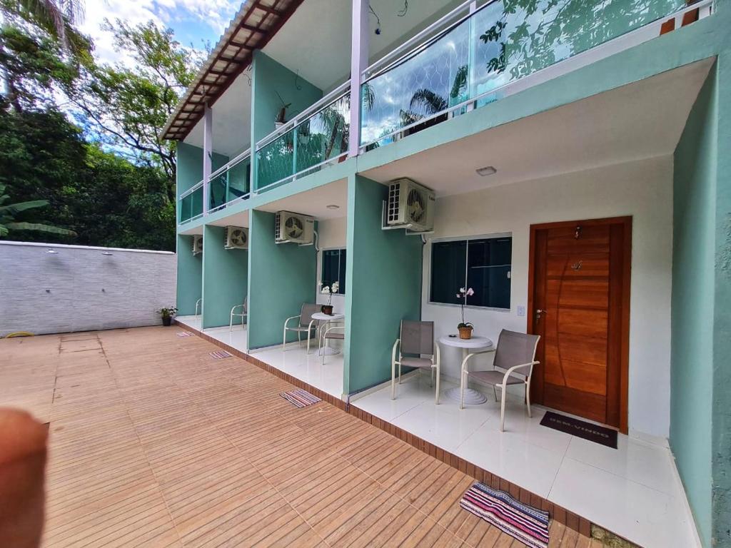 einen Balkon eines Hauses mit einem Tisch und Stühlen in der Unterkunft Suites Golfo in Abraão