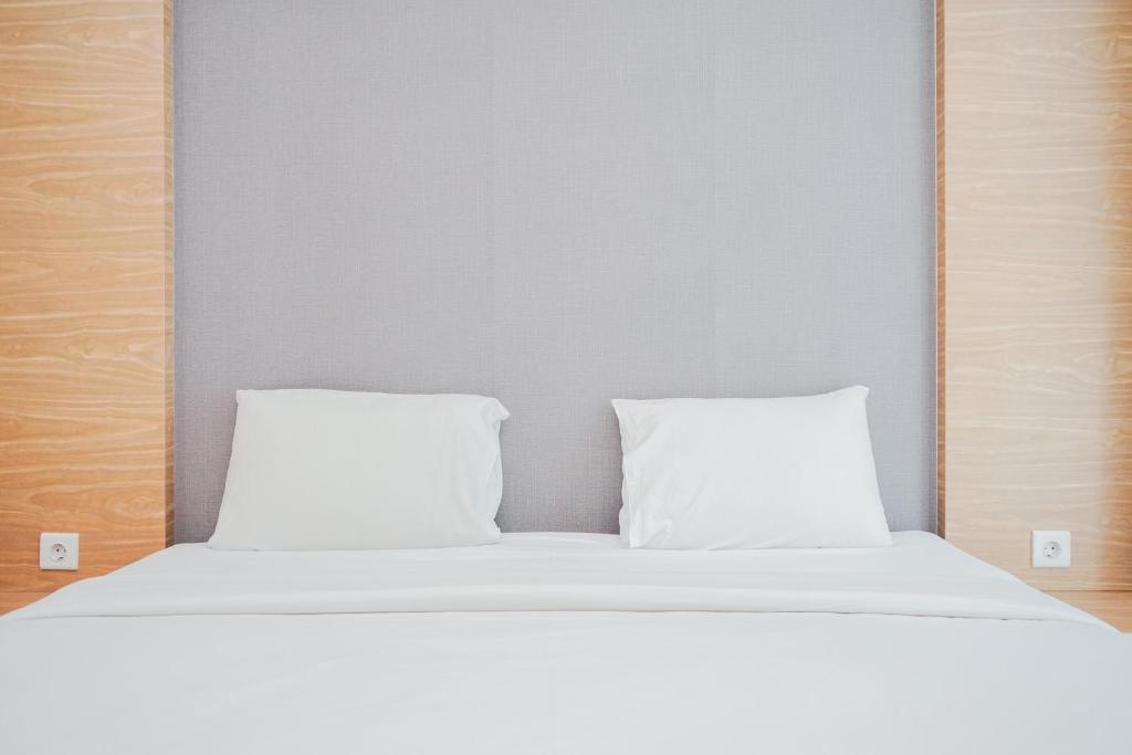 ein weißes Bett mit zwei Kissen darüber in der Unterkunft Great Choice 1BR at Brooklyn Alam Sutera Apartment By Travelio in Dongkal Dua