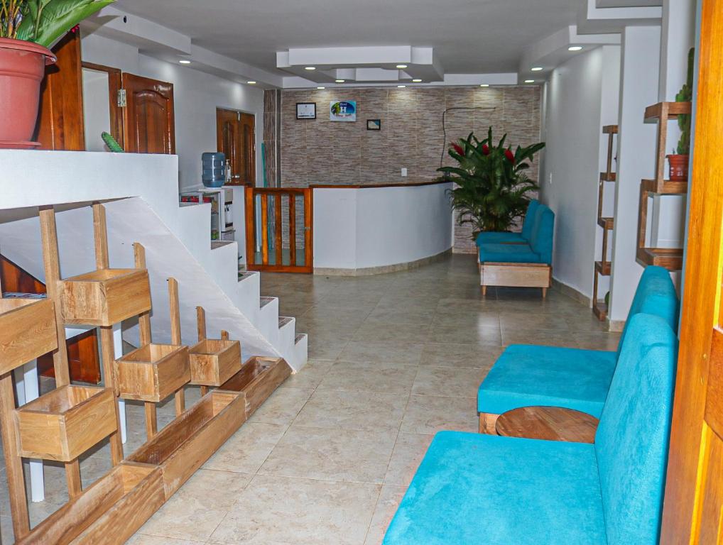 un vestíbulo con escalera y sillas azules en Hotel Arena Azul, en Nuquí