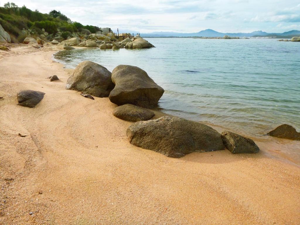 a group of rocks sitting on a sandy beach at Cala Cuncheddi - VRetreats in Murta Maria