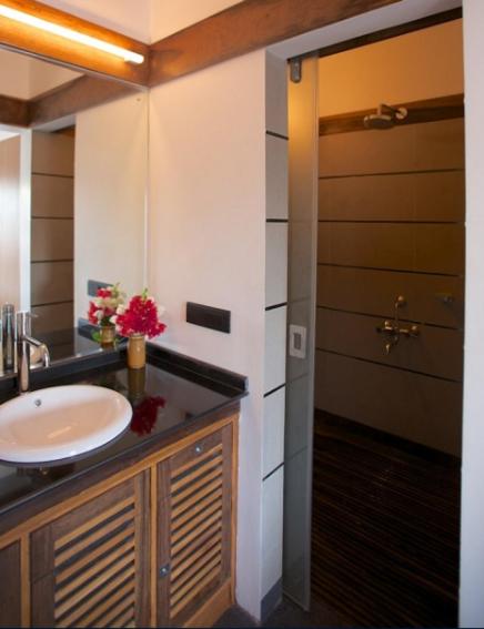 a bathroom with a sink and a mirror and a door at Dunhill Beach Resort in Agonda