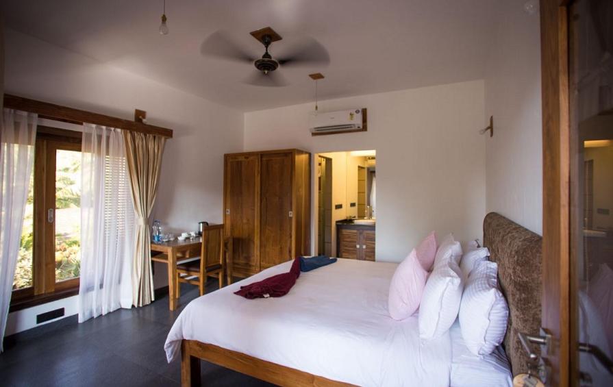 a bedroom with a bed with white sheets and pillows at Dunhill Beach Resort in Agonda