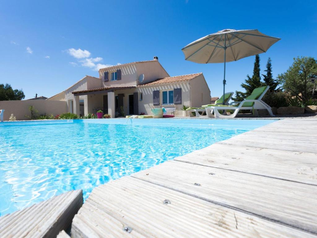 BeaufortにあるLuxurious Villa in Beaufort with Swimming Poolの傘付きのスイミングプール、家