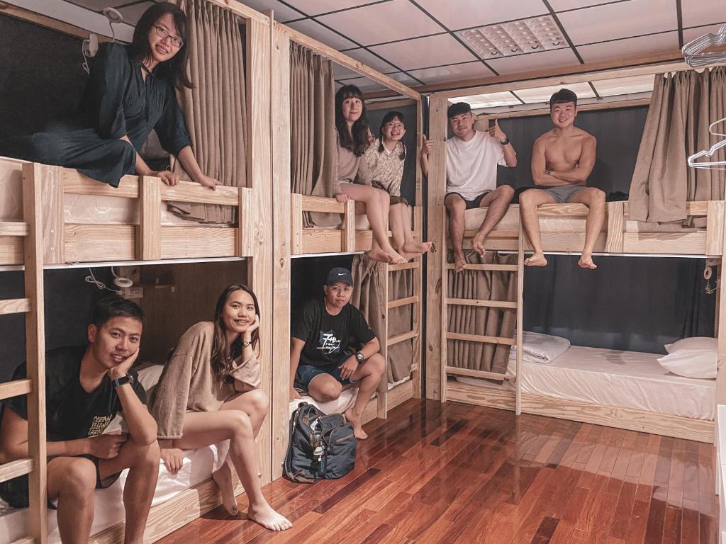 a group of people sitting on top of bunk beds at InnOcean在海裡潛水旅宿 Liuqiu Dive Hostel in Xiaoliuqiu