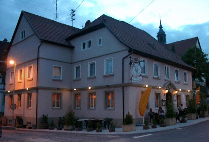 a large building with people sitting outside of it at Hotel Drei Könige in Neckarbischofsheim