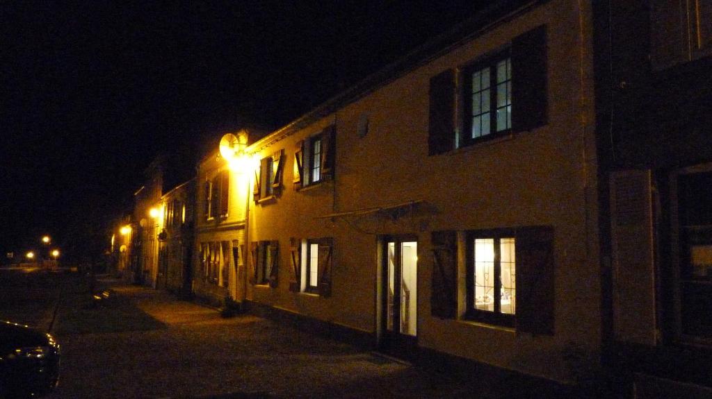 a building with a light on the side of it at night at La Maison Cent 5 avec parking privé in Saint-Valéry-sur-Somme