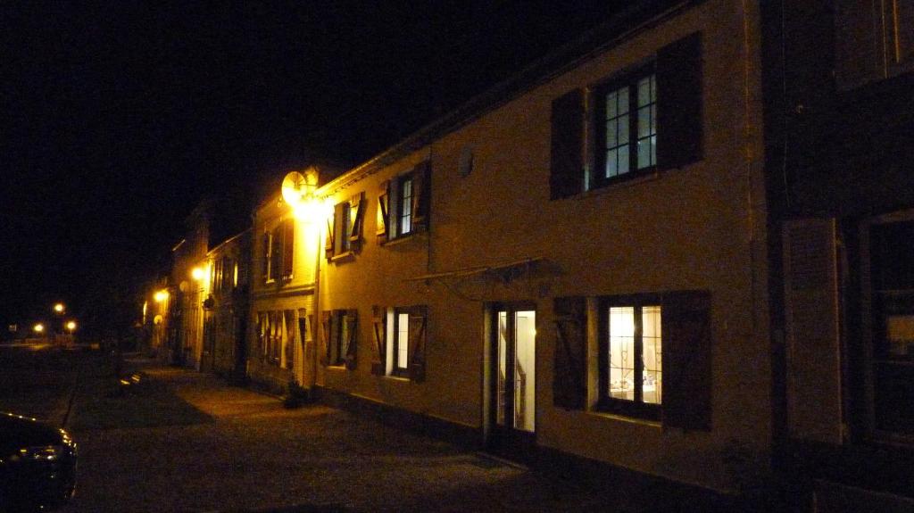 a building with a light on the side of it at night at La Maison Cent 5 avec parking privé in Saint-Valery-sur-Somme