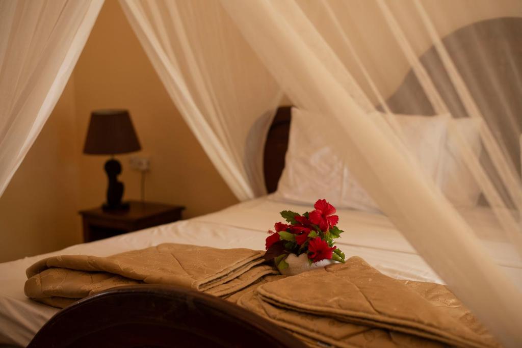 a bed with a bouquet of flowers on it at Sea View Beach Hotel in Zanzibar City