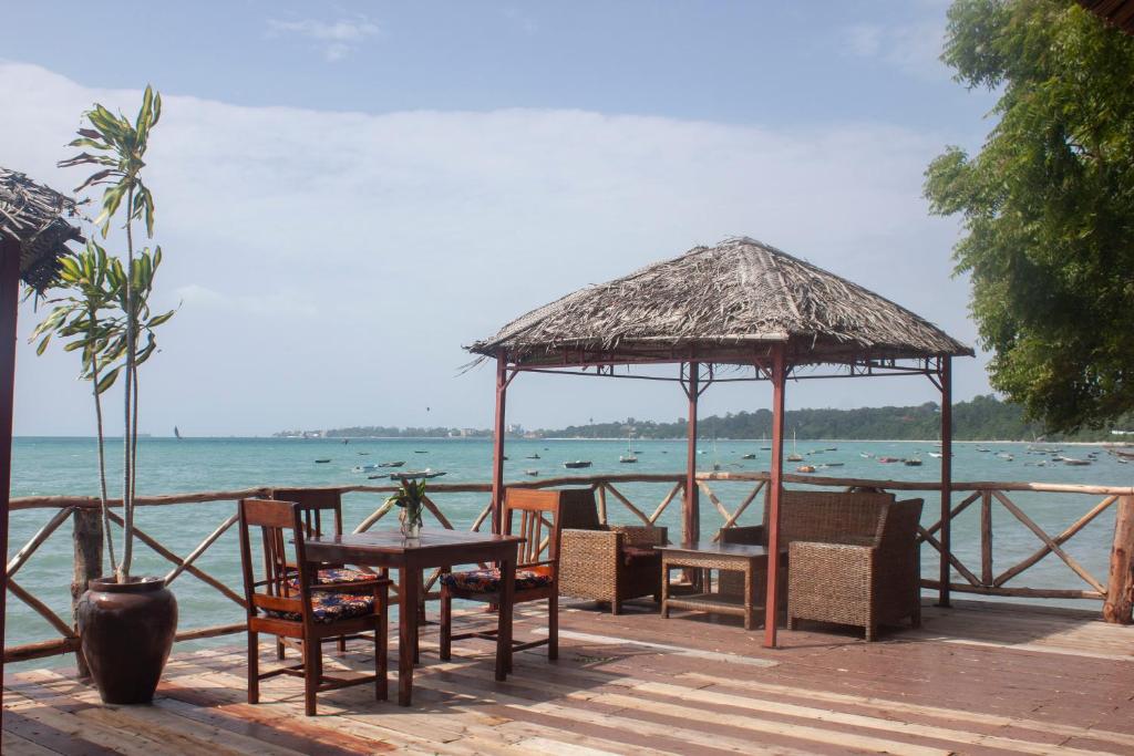 a restaurant with tables and chairs on the beach at Sea View Beach Hotel in Zanzibar City