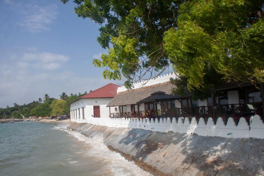 a building on the beach next to the water at Sea View Beach Hotel in Zanzibar City