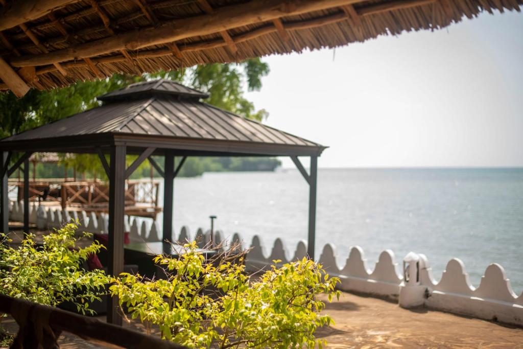 a gazebo next to a body of water at Sea View Beach Hotel in Zanzibar City