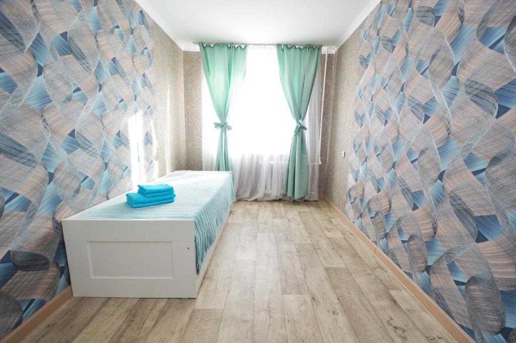 een slaapkamer met een bed en een raam bij Мода в доме 14 in Oral