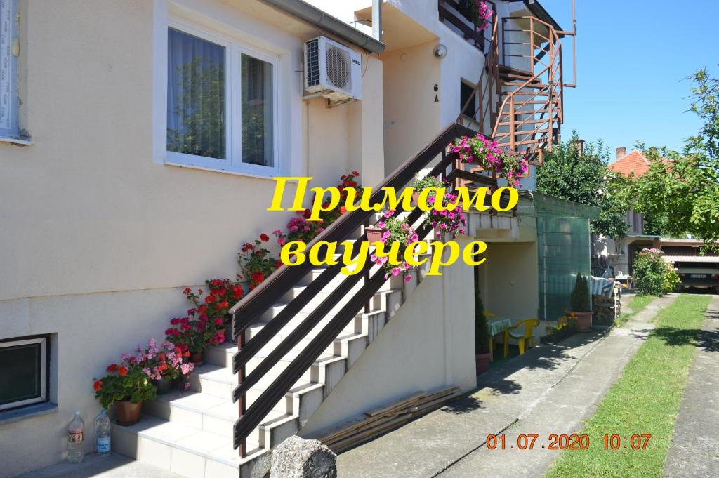 une maison avec des escaliers et des fleurs sur le côté. dans l'établissement Apartmani Perovic, à Sokobanja