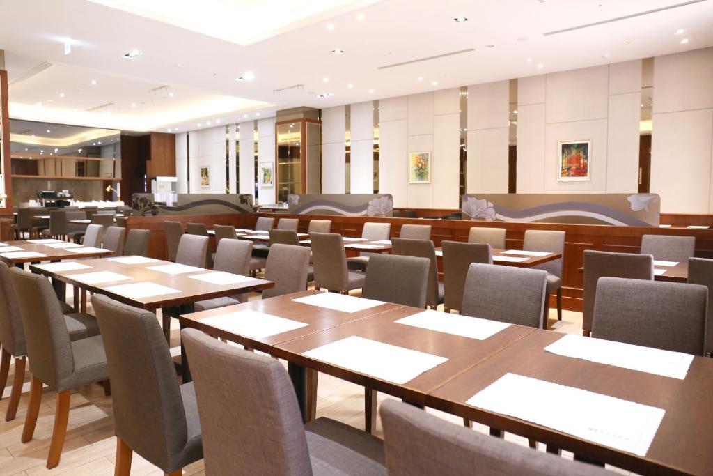 a dining room with wooden tables and chairs at Fushin Hotel - Tainan in Tainan
