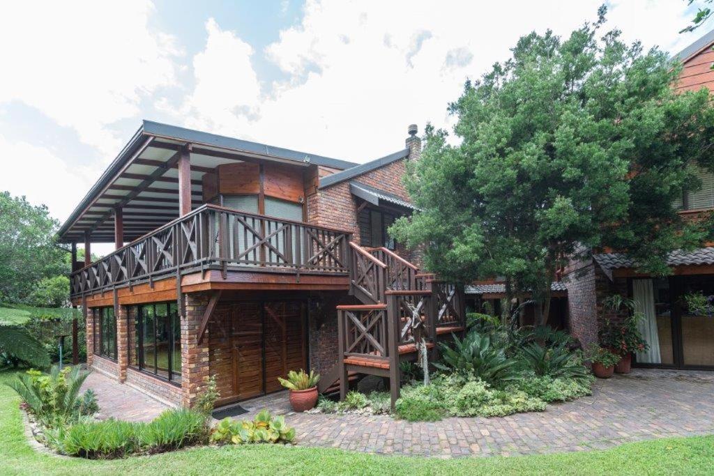 a house with a balcony and a tree at Kamma-Otter in Natureʼs Valley