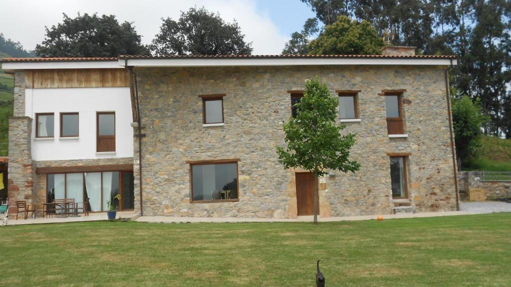 una casa de piedra con un árbol delante en Casa Narzana, en Villar