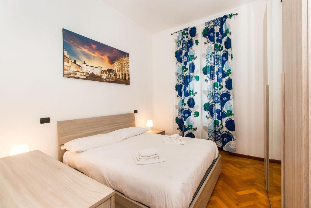 ein kleines Schlafzimmer mit 2 Betten und einem Fenster in der Unterkunft Piazza Bengasi Cozy Apartment in Turin