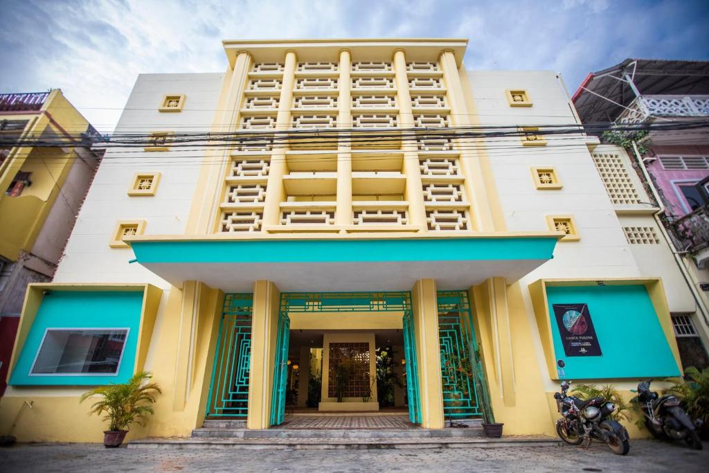 a large white building with blue trim at Hotel Old Cinema in Kampot