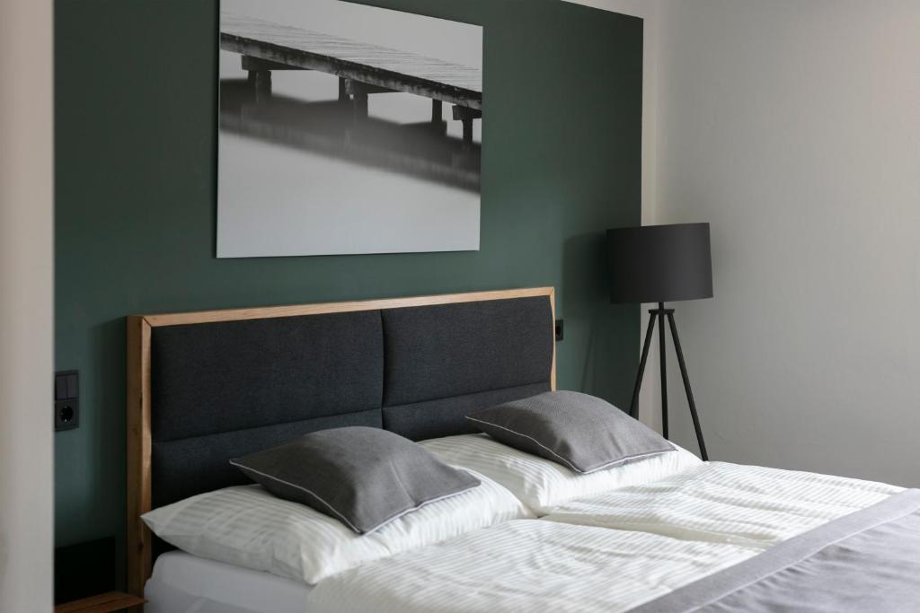 ein Bett in einem Schlafzimmer mit einer grünen Wand in der Unterkunft KRACHER Guesthouse No 6 in Illmitz