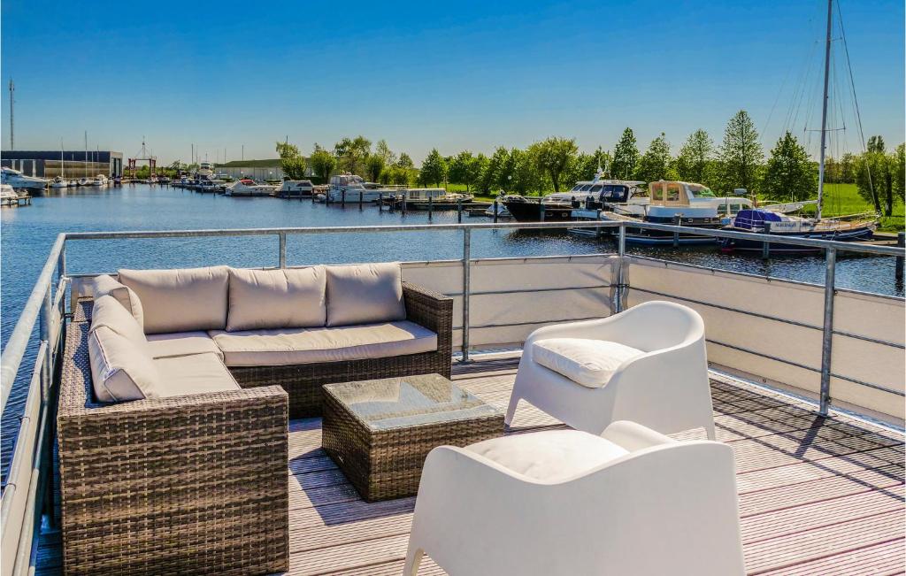 a deck with couches and chairs on a boat at Nice ship-boat in Aalsmeer with 2 Bedrooms and WiFi in Leimuiden