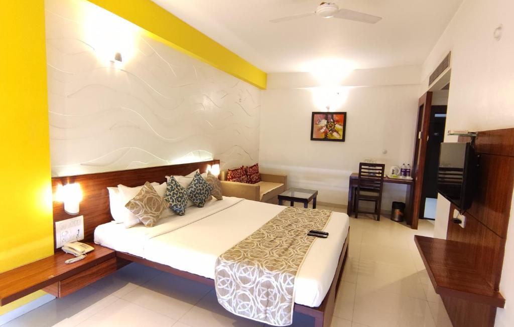 a hotel room with a bed and a television at The Temple View Hotel in Shirdi