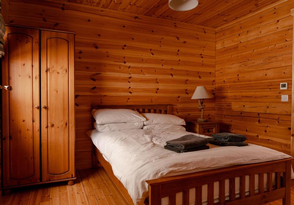 um quarto com uma cama num chalé de madeira em Pentland Lodge em Gorebridge