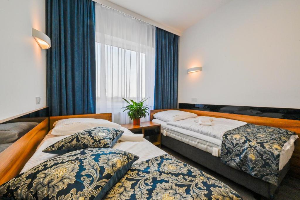 a hotel room with two beds and a window at Hotel Terminal in Gorzów Wielkopolski