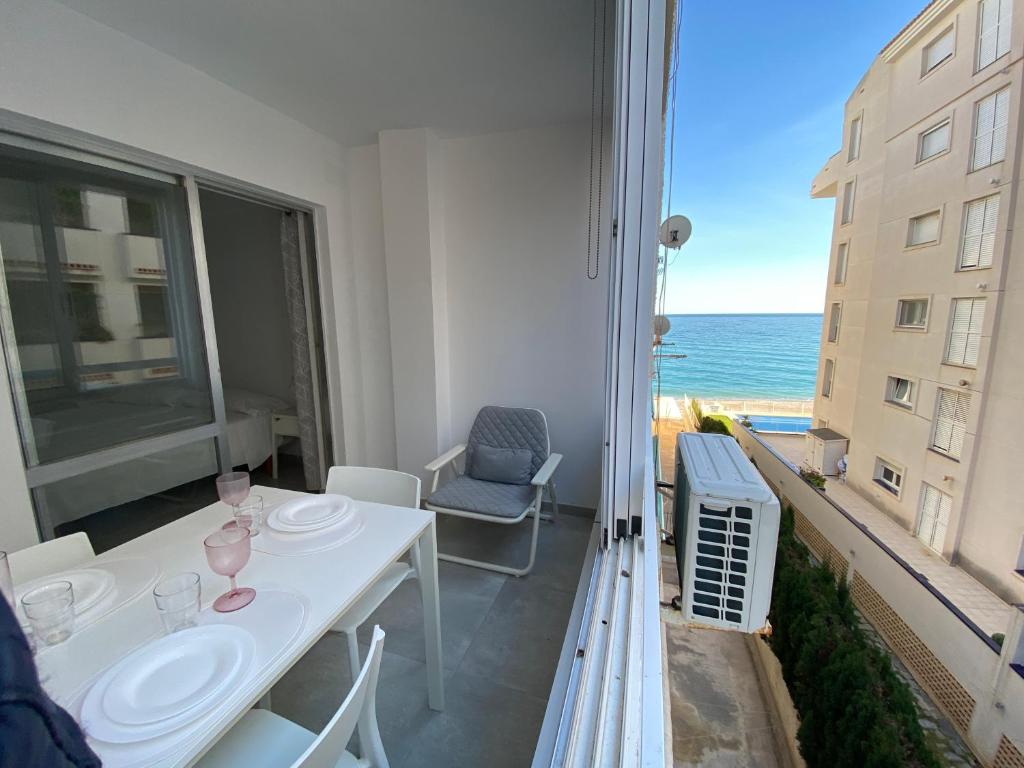 een witte tafel en stoelen op een balkon met uitzicht op de oceaan bij Cap Negret 30 in Altea