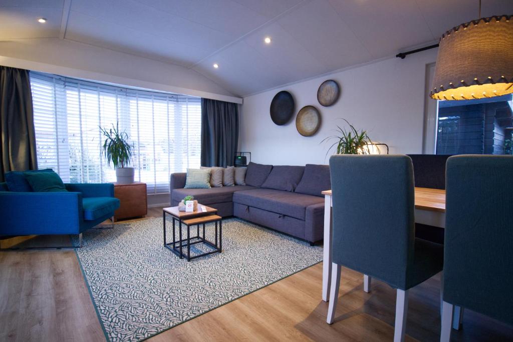 a living room with a couch and a table at chalet hensbroek in Hensbroek