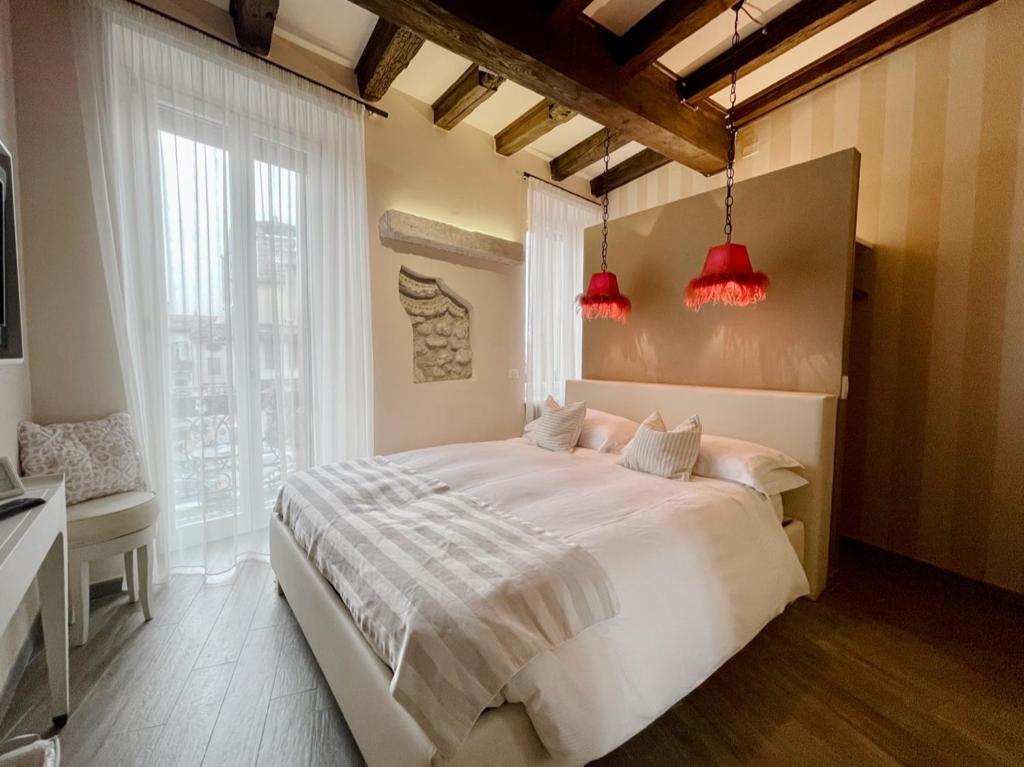 1 dormitorio con 1 cama blanca grande con luces rojas en B&B Verona Centro, en Verona