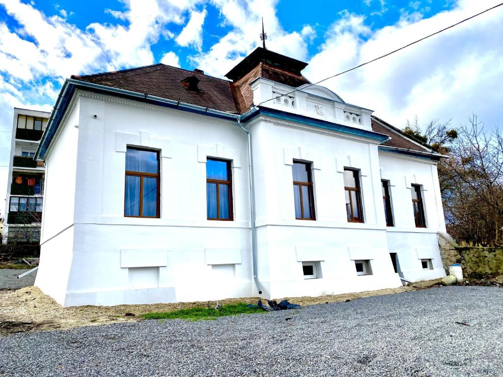 ein weißes Gebäude mit braunem Dach in der Unterkunft Szinyei Merse-Kastély in Sátoraljaújhely
