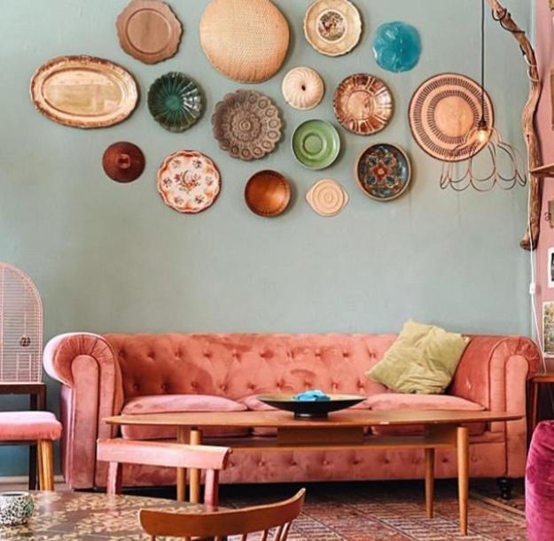 a living room with a couch and plates on the wall at Baggå Skola BnB & Café in Skinnskatteberg