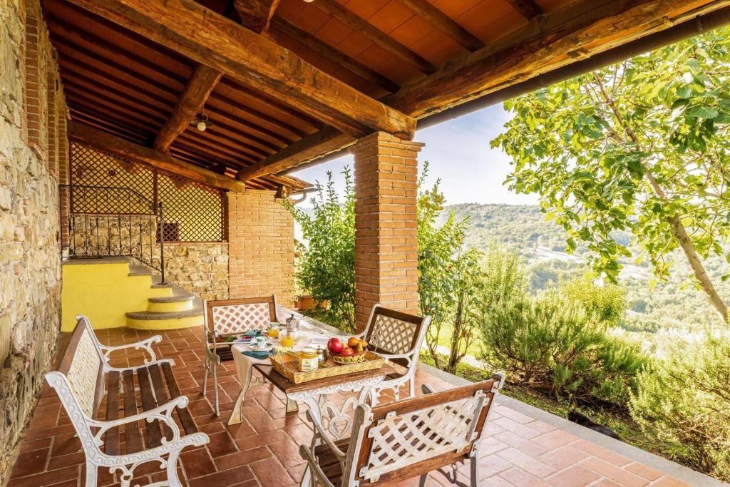 patio con mesa, sillas y vistas en Gilda, en Roccalbegna