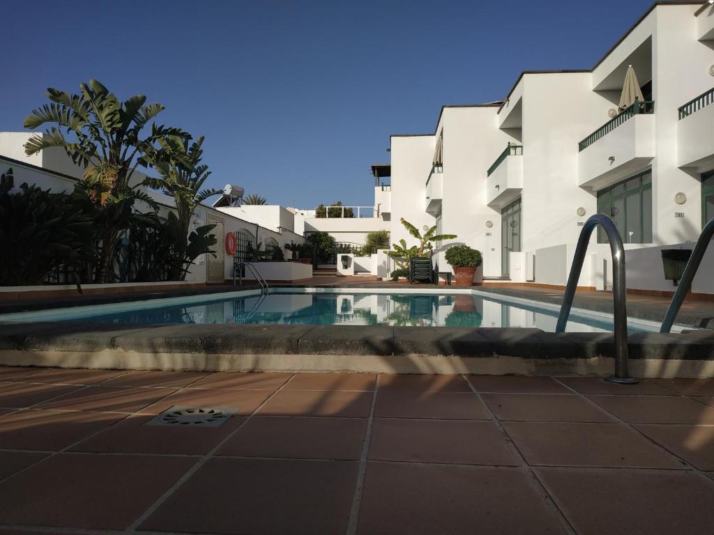 una piscina di fronte a un edificio di Apartamentos La Tegala a Puerto del Carmen