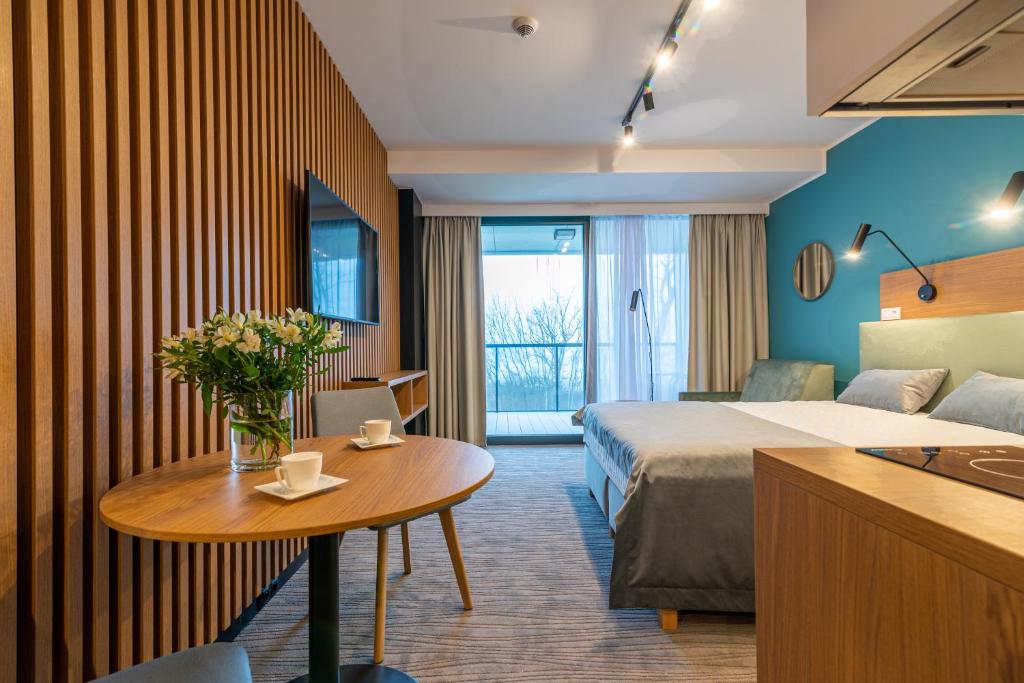 a hotel room with a bed and a table at Seaside Apartaments Deluxe 105 in Kołobrzeg