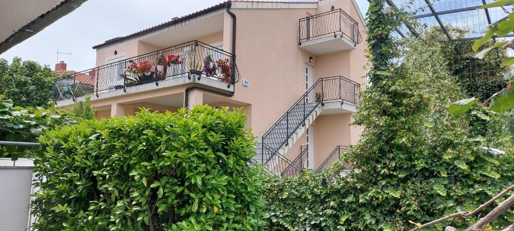 a building with balconies and plants in front of it at Apartmani Tomislav in Krk
