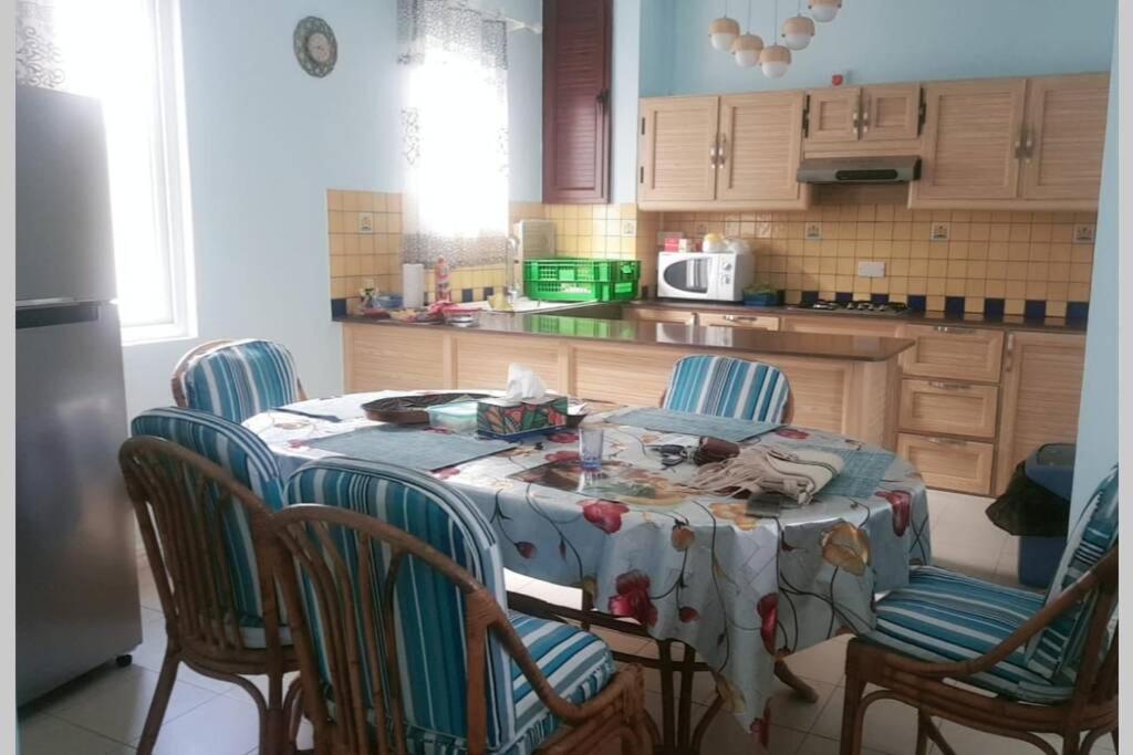 a kitchen with a table with four chairs and a kitchen at Well equipped peaceful 3 bedroom apartment in Flic-en-Flac