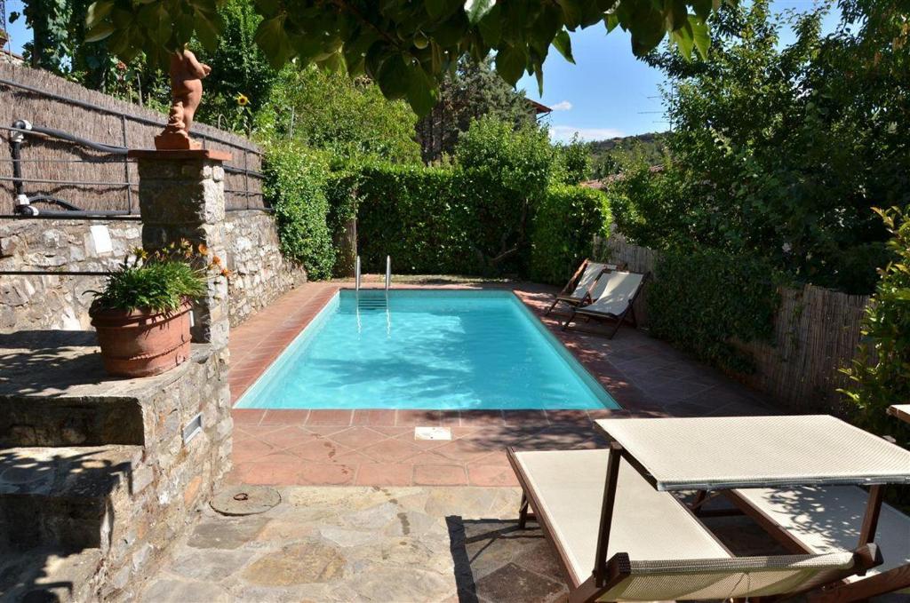 uma piscina num quintal com mesa e cadeiras em Ciacchieri em Gaiole in Chianti