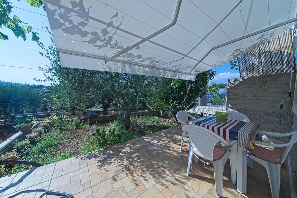 a table and chairs under an umbrella on a patio at Apartment Alva in Splitska