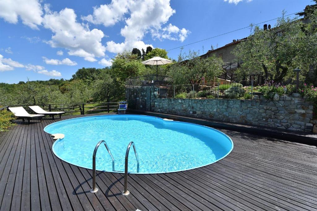 uma piscina num deque de madeira com uma mesa e um banco em Casa Silvia em San Casciano in Val di Pesa