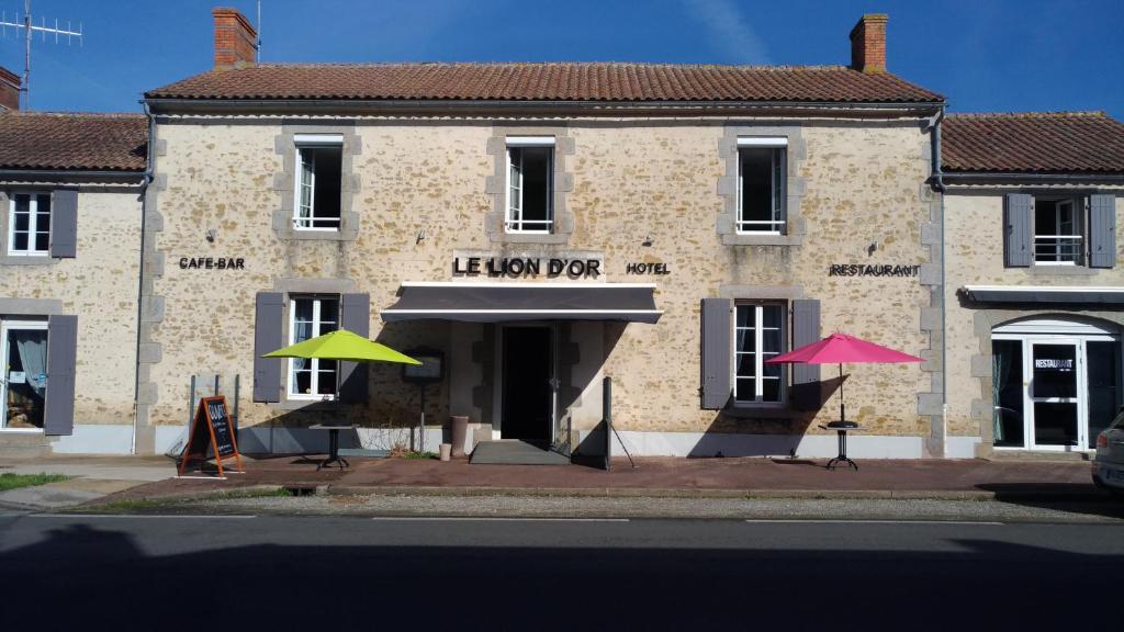 um edifício com dois guarda-chuvas à frente em LE LION D'OR em Avrillé